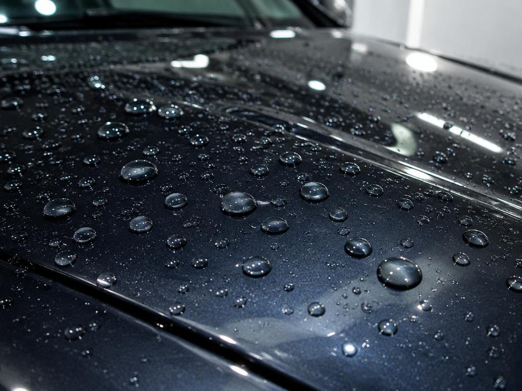 Water beading on a dark car hood